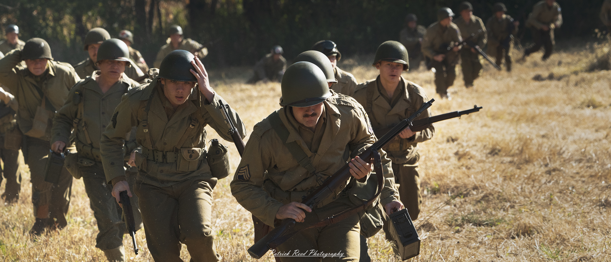 "Dynamic scene of World War II U.S. soldiers charging forward, displaying bravery and determination in the heat of battle. The soldiers are depicted in full military gear, including helmets and weapons, sprinting across a rugged terrain, with expressions of focus and resolve. The background is filled with the chaotic atmosphere of combat, possibly with smoke, explosions, or distant enemy fire, emphasizing the intensity of the moment. This powerful image captures the spirit of teamwork and courage among American troops during one of history's most significant conflicts."